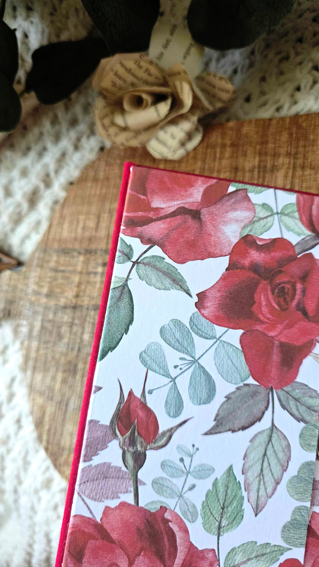 Red book with floral design end pages on a textured surface