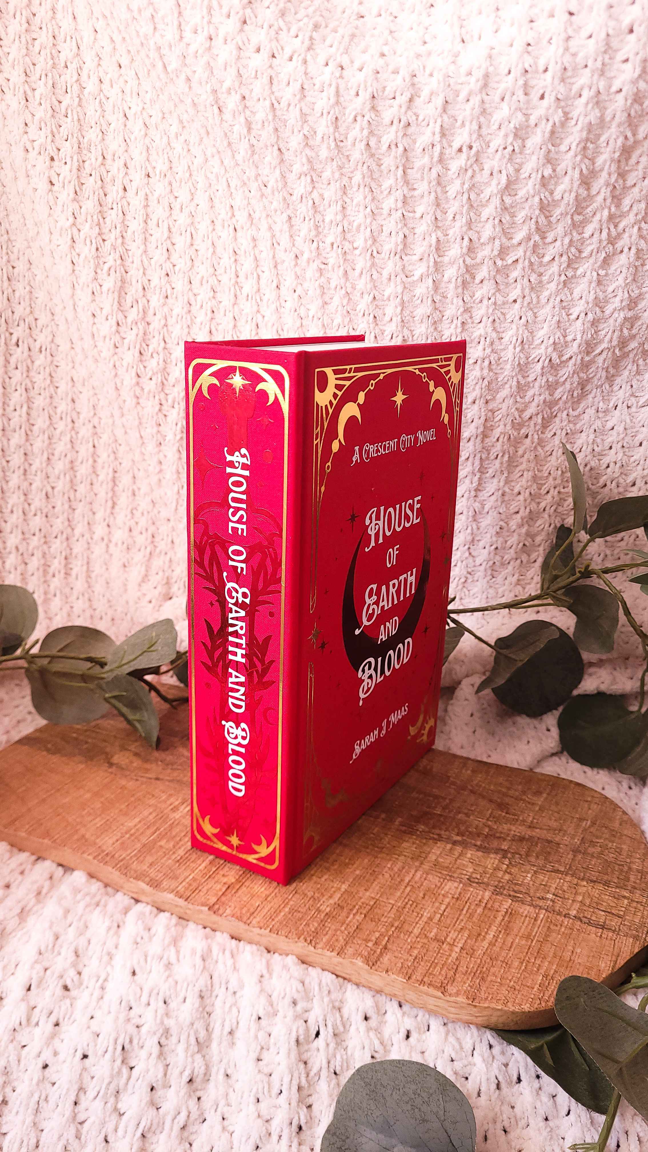 Handmade rebound of House of Earth and Blood in red bookcloth with red, white, and gold accents