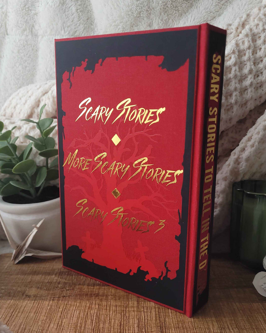 Red book titled 'Scary Stories' with black cover on a wooden surface.